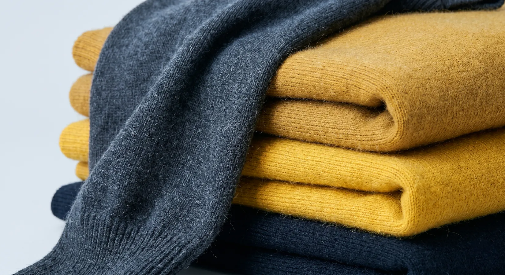 A close-up of a pile of folded knitwear